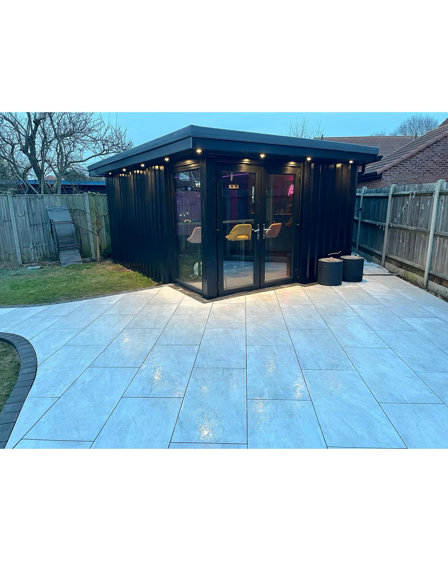 Black timber garden room with patio and lawn